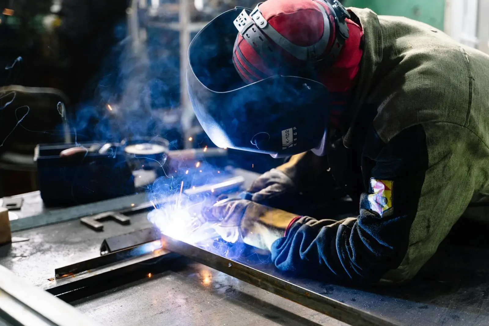 Soudeur avec masque de protection en plein travail dans un atelier